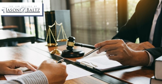 Hands of an attorney with reviewing a document with a client and a gavel in the background